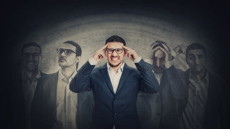 Businessman with multipolar disorder splits emotions into different inner personalities. Mental health concept and schizophrenia psychiatric disease. Dementia panic reactions and mood changeの写真素材