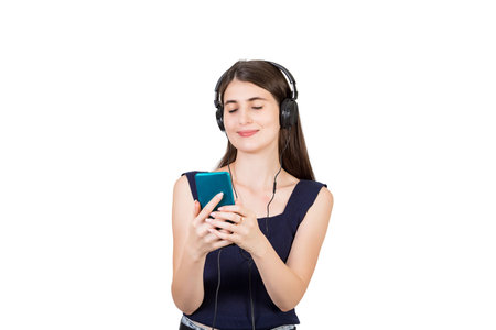 Relaxed casual woman listening calming music on headphones, holding her phone with closed eyes isolated over white backgroundの写真素材
