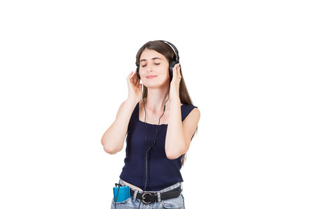 Contented girl listening relaxing music on her phone, keeps hand to headset and eyes closed isolated over white backgroundの写真素材