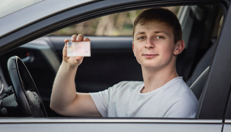 Guy shows the driver license out of the car windowの写真素材