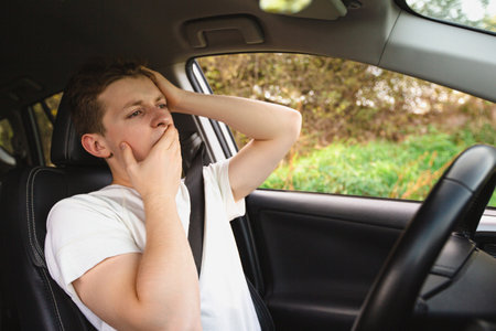 Stressed and bewildered driver, pissed off keeps hands to head, has traffic problems. Unlucky man has a road accidentの写真素材