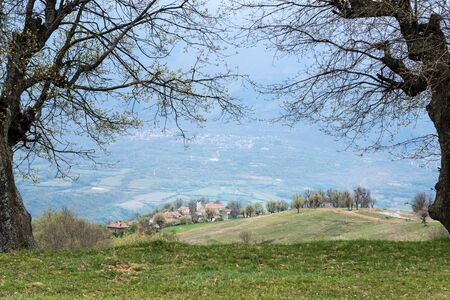 Spring scene in a countryside. Small village, meadows, blooming trees.の写真素材