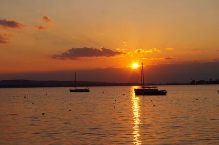 Boats on the lake at sunsetの写真素材