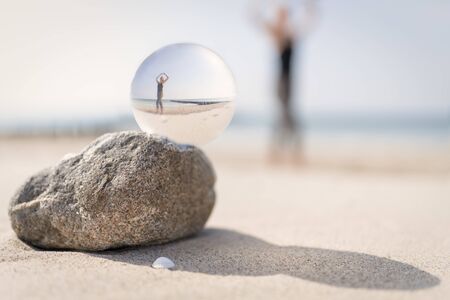 Yoga on the Baltic Sea beach, photographed through a glass ballの写真素材