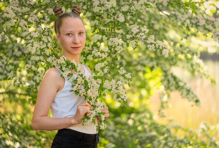Young, caucasian girl posing in nature in the light-flooded evening light.の写真素材