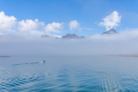 A tourist Zodiac enters the foggy bay of the now abandoned whaling station at Grytviken - on the...