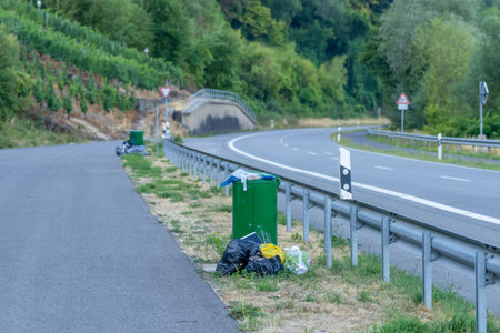 An overflowing rubbish bin at the roadside shows problems with disposal. Possible causes are strikes or other difficultiesの写真素材