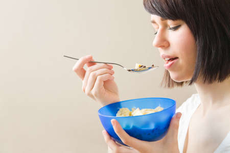 Young woman eating a bowl of muesli