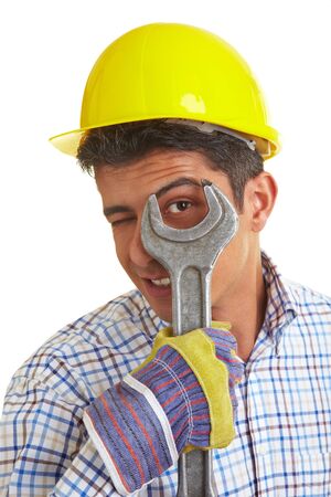 Construction worker looking through a big jaw wrenchの写真素材