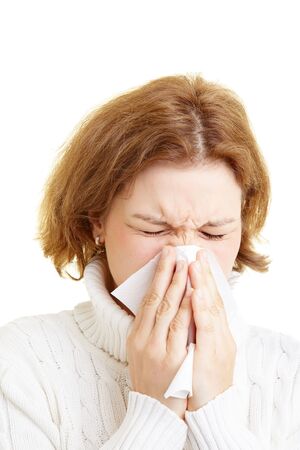 Woman cleaning her nose with a tissueの写真素材