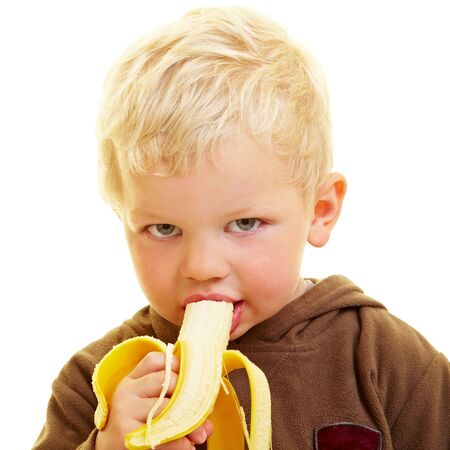 Young boy eats a bananaの写真素材