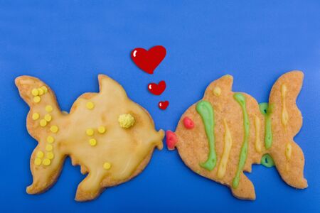 Two cookie fish kiss each other with hearts coming upの写真素材