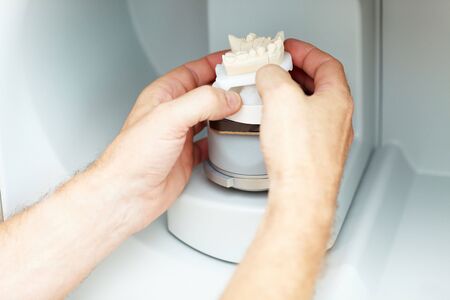 Dental technician placing a dental model in a 3D scannerの写真素材