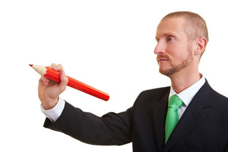 Manager writing with an oversized red pencilの写真素材