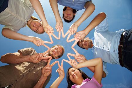 Five friends connecting their hands to star shape