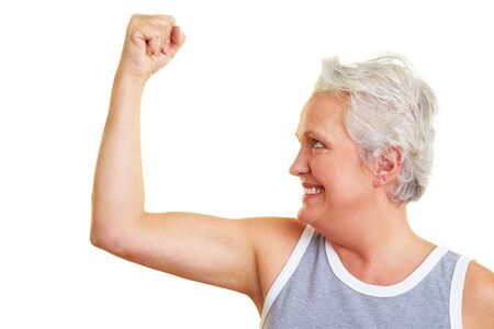 Happy senior woman showing her upper arm musclesの写真素材