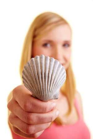 Young happy woman holding a cockle in her hand