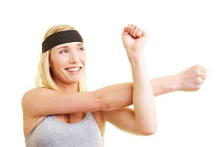 Smiling young woman with headband stretching her arms