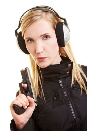 Young female shooter with pistol and ear protection