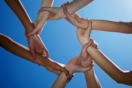 Four people holding each other on the wristsの写真素材
