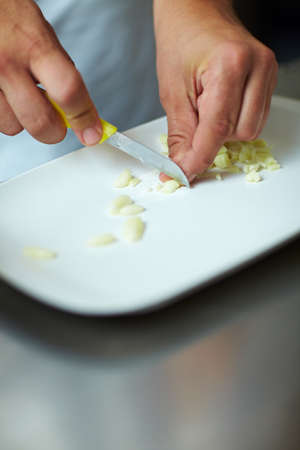 Chef cutting garlic in many small piecesの写真素材