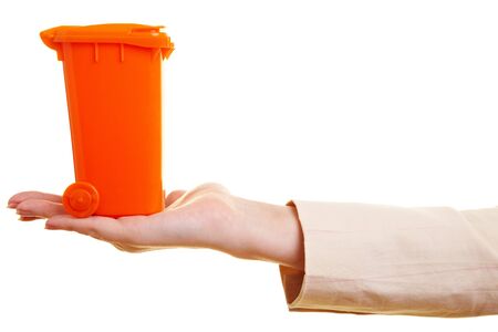 Small orange garbage can standing on a handの写真素材