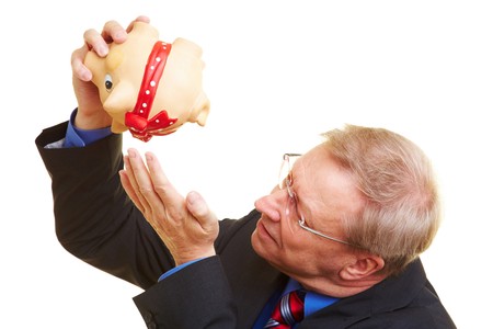 Senior businessman shaking an empty piggy bankの写真素材