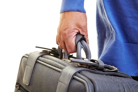 Female senior citizen carrying a gray suitcaseの写真素材