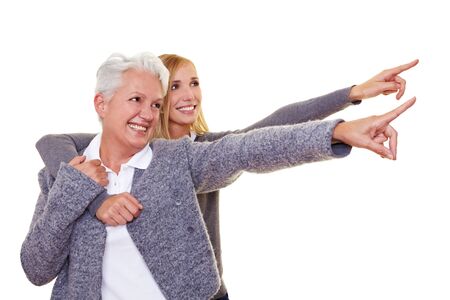 Grandmother and granddaughter pointing with their index fingersの写真素材