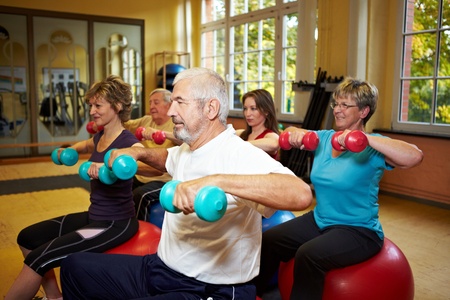 Group working out with dumbbells in gym