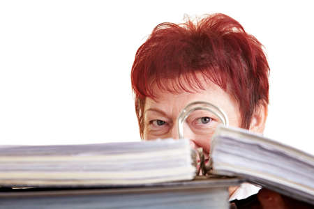 Elderly business woman hiding behind her files