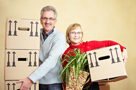 Two happy senior people with many moving boxesの写真素材