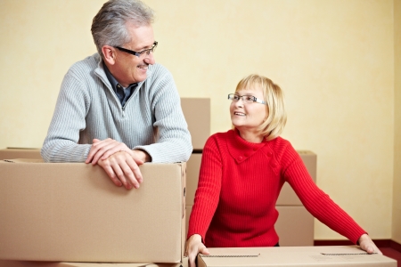 Two happy senior people with many moving boxesの写真素材