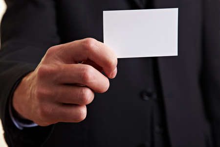 Hand holding an empty white business cardの写真素材