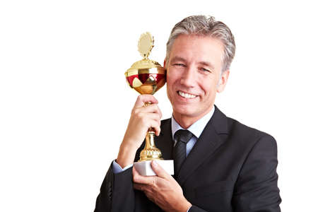 Happy senior business man holding a trophy in his handsの写真素材