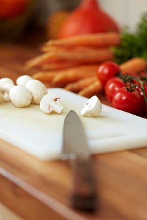 Knife point on cutting board with White mushroomsの写真素材