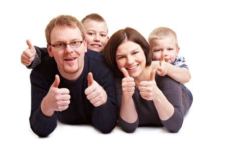 Happy family with two children holding their thumbs upの写真素材