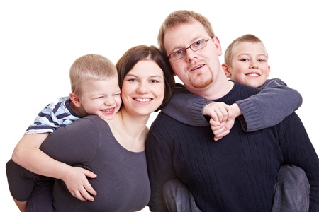 Father and mother carrying their two children piggybackの写真素材