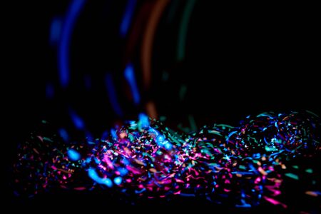 Colorful abstract confetti light in front of black backgroundの写真素材