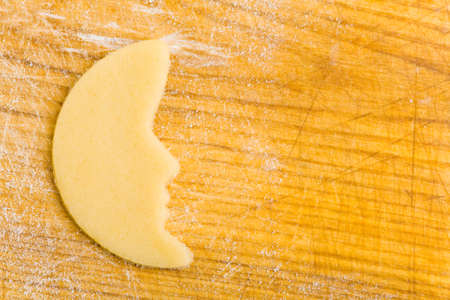 Moon shaped raw cookie dough on cutting boardの写真素材