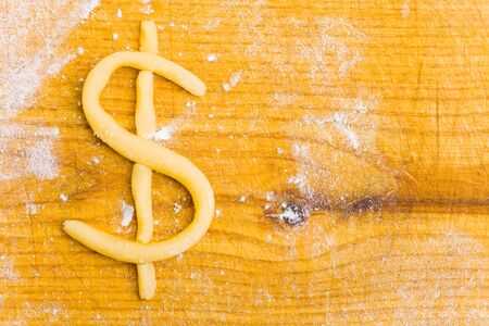 Dollar symbol as christmas cookie on wooden boardの写真素材