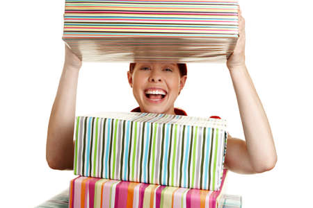 Happy woman looking through stack of christmas gifts