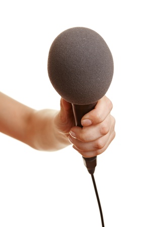 Hand holding a microphone with a windscreenの写真素材