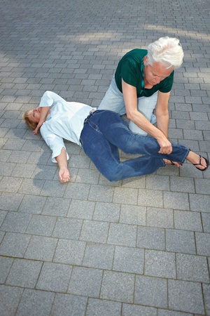 Senior woman using recovery position on unconscious womanの写真素材