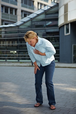 Exhausted woman with shortage of breath in cityの写真素材