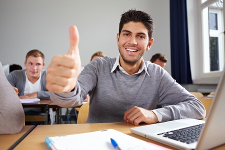 Happy student holding his thumb up in university classの写真素材