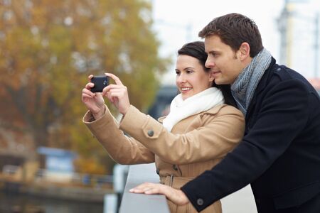 Tourists on a city trip taking photos with smartphoneの写真素材