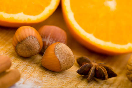 Hazelnuts and oranges with spices on cutting boardの写真素材