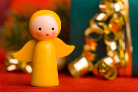 Small yellow christmas angel with decorated giftの写真素材