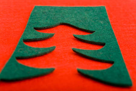 Cut out christmas tree shape on green felt on red background